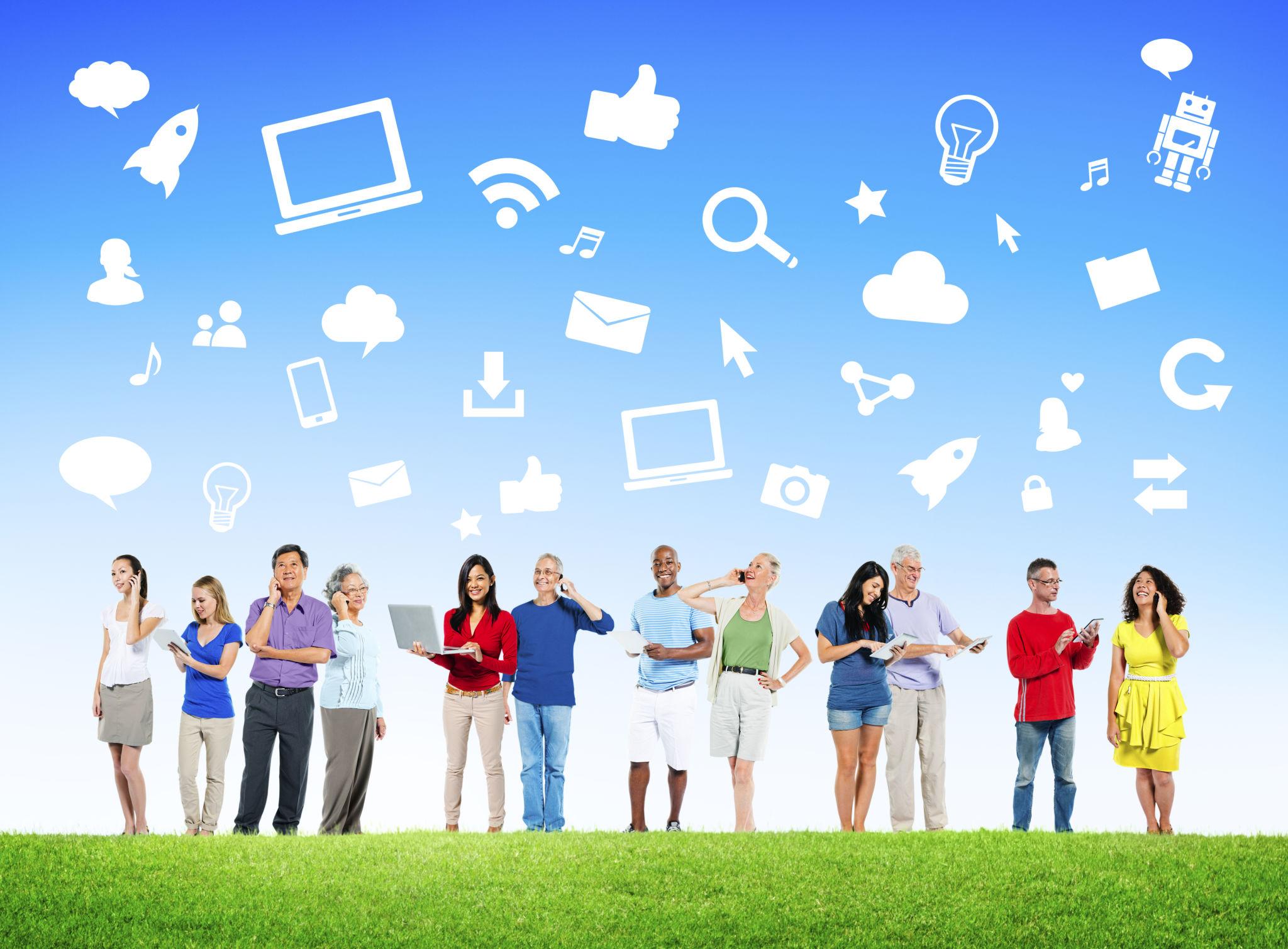 Un groupe de personnes de différents âges et origines se tient côte à côte sur une pelouse verte, utilisant smartphones, tablettes et ordinateurs.
Au-dessus d’eux, des pictogrammes numériques (Wi-Fi, cloud, email, ampoule, ordinateur, partage) flottent sur un fond bleu.
L’image symbolise l’inclusion numérique, la diversité et l’autonomie dans un écosystème digital connecté.